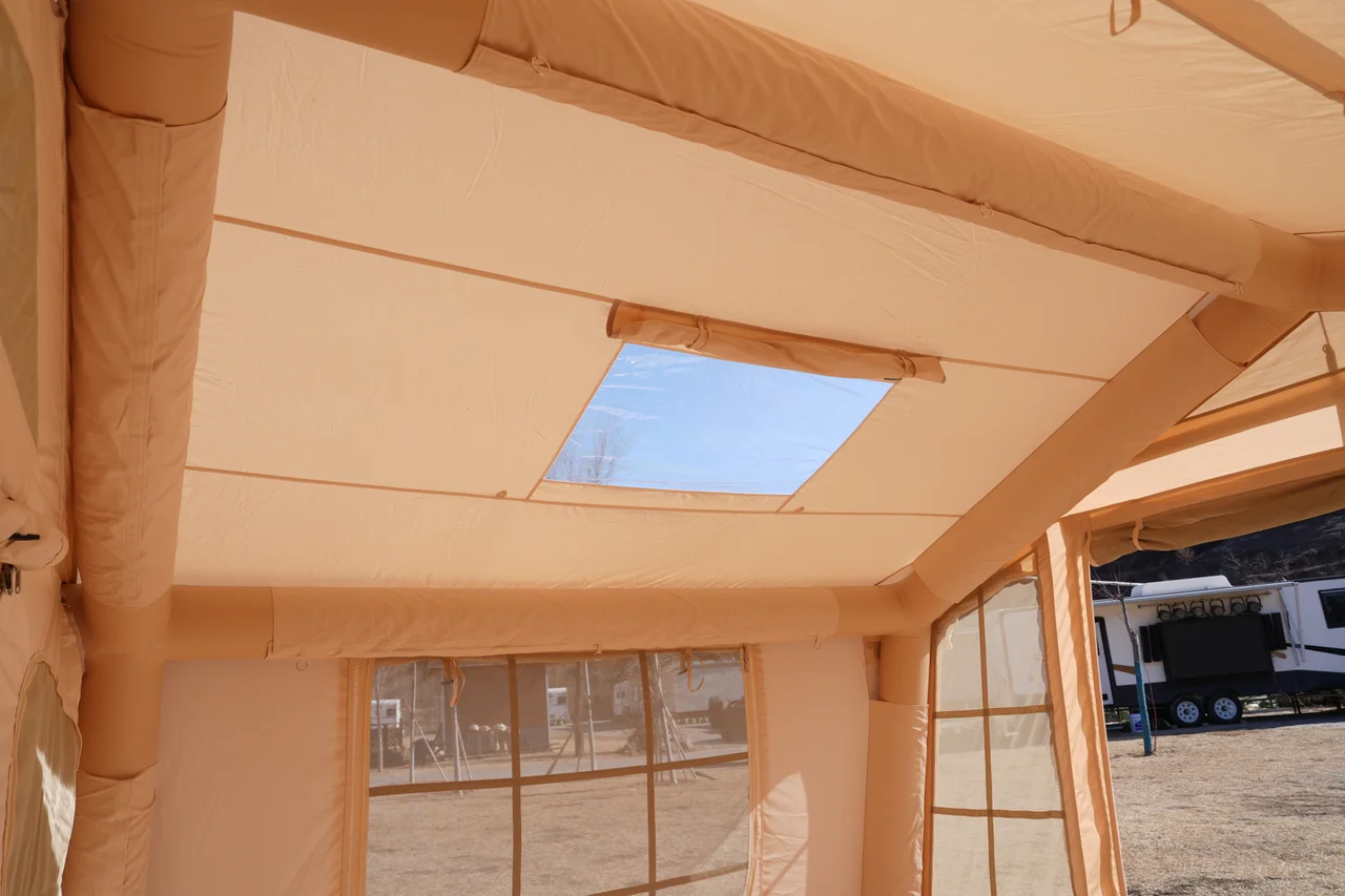 Roof opening and inflatable frame viewed from inside a beige lodge tent