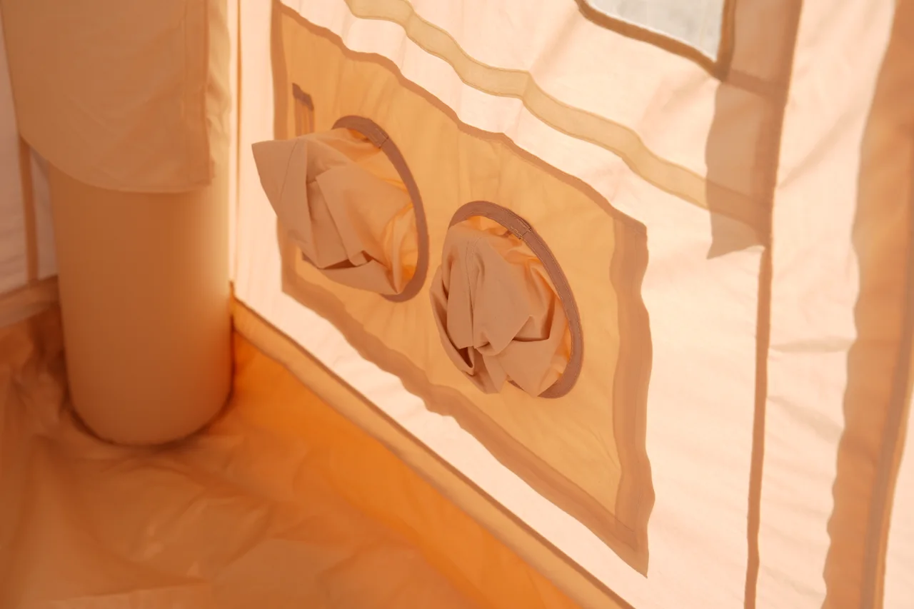Pair of low-level circular openings inside a beige inflatable lodge