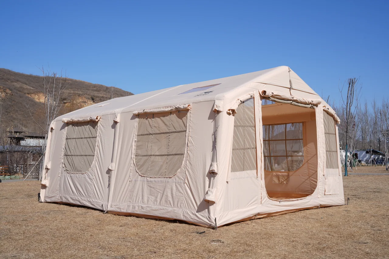 Large light-coloured inflatable lodge tent viewed from the front corner