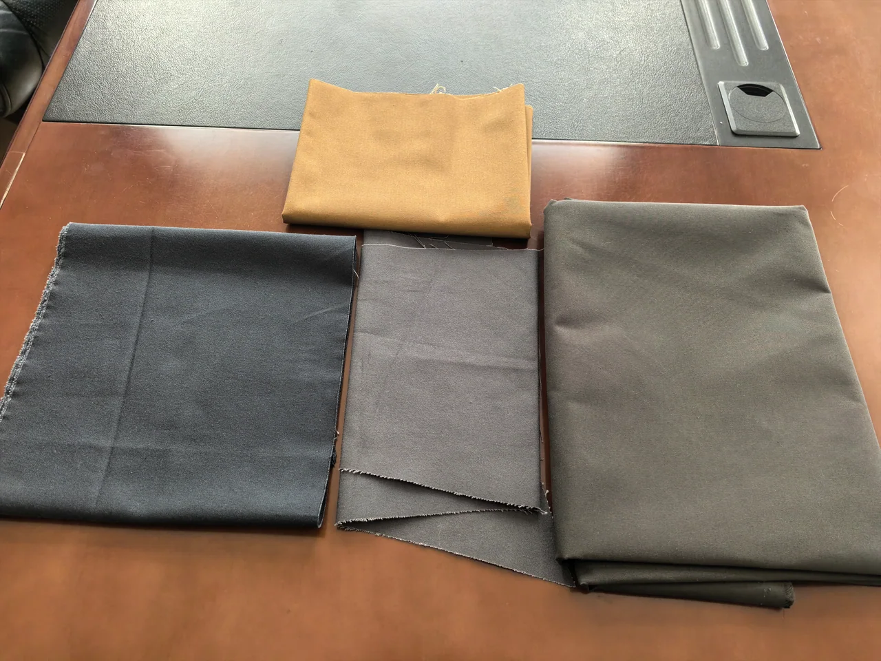 Physical tent fabric swatches in several colours on a work table
